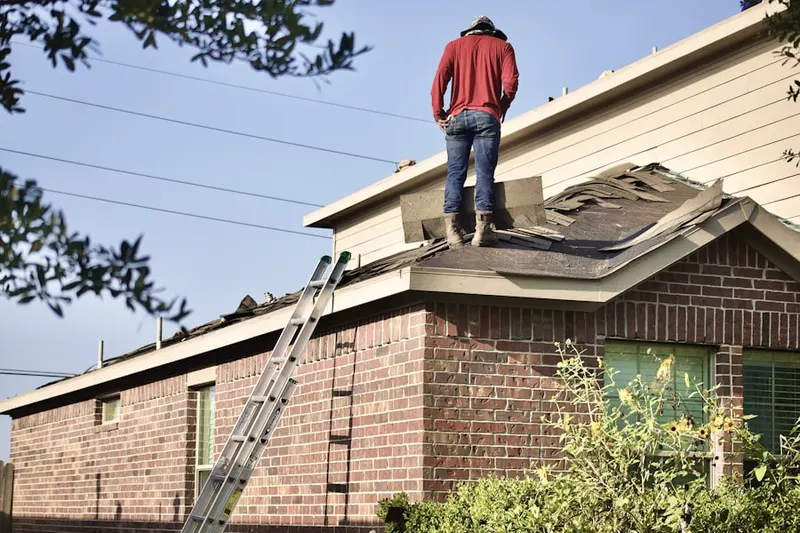 Professional roofer working on a residential roof in Hollin Hills